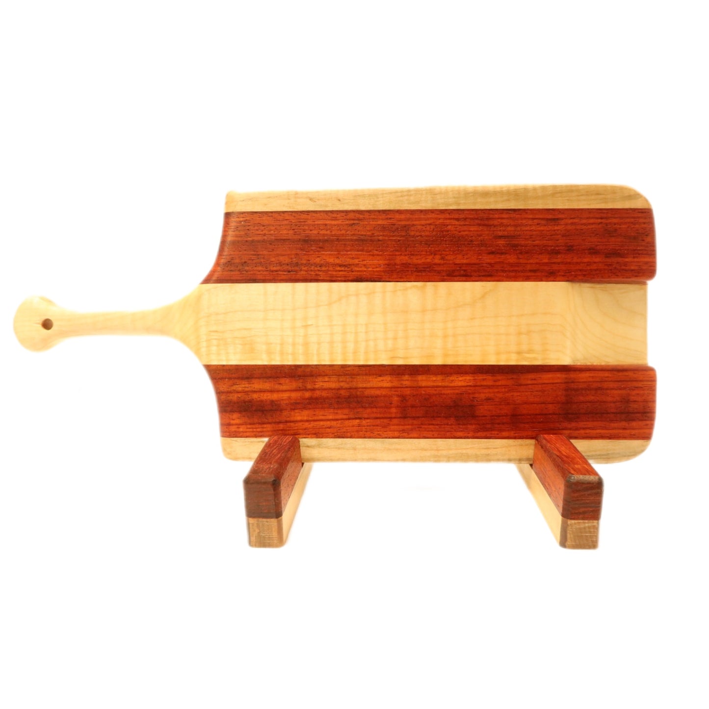 "Padauk and curly maple charcuterie board with raised handle. The board features a unique combination of warm reddish-brown padauk and light-colored curly maple, with a raised handle for easy carrying. Perfect for serving cheeses, meats, bread, crackers, fruit, and more. A stunning display piece that is sure to impress your guests."